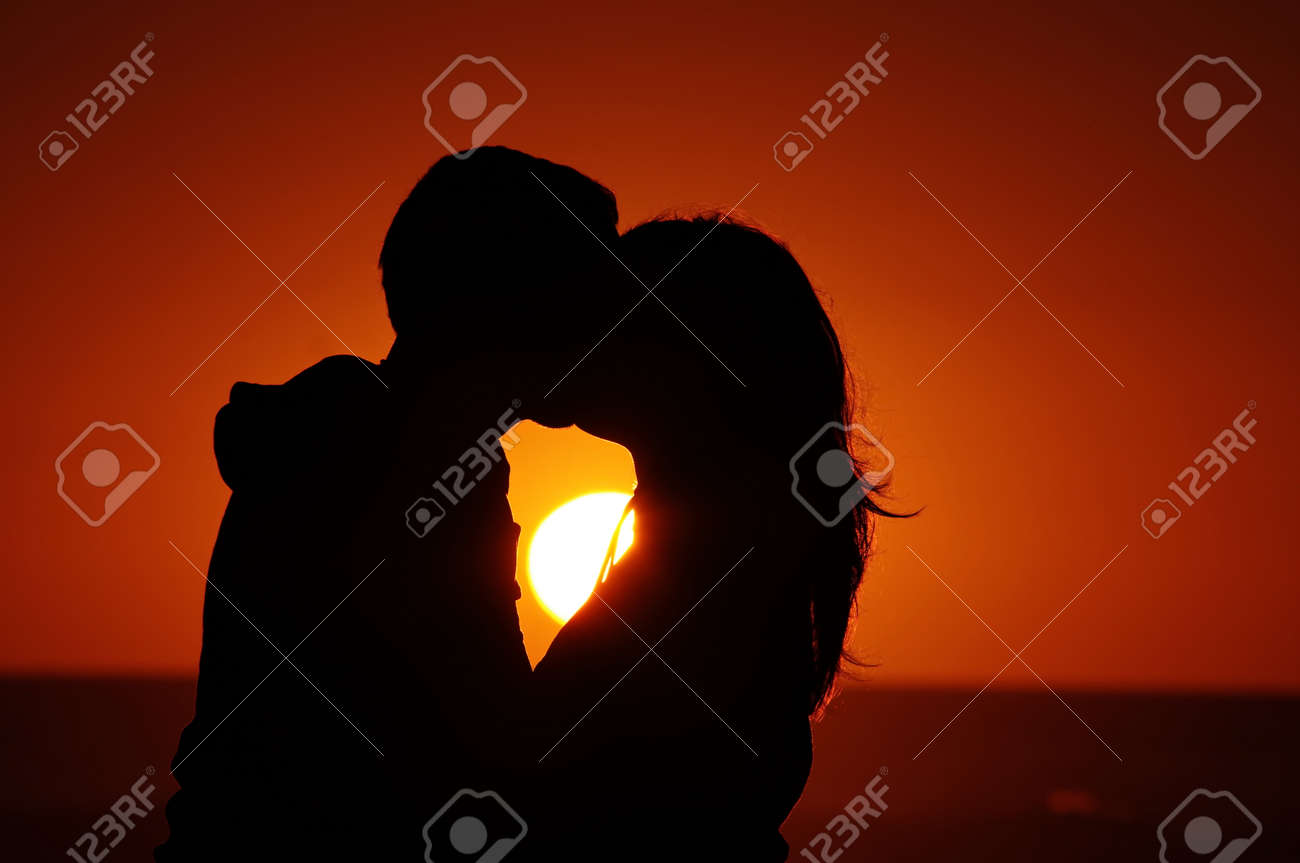ビーチで夕日を背景にカップル の写真素材 画像素材 Image