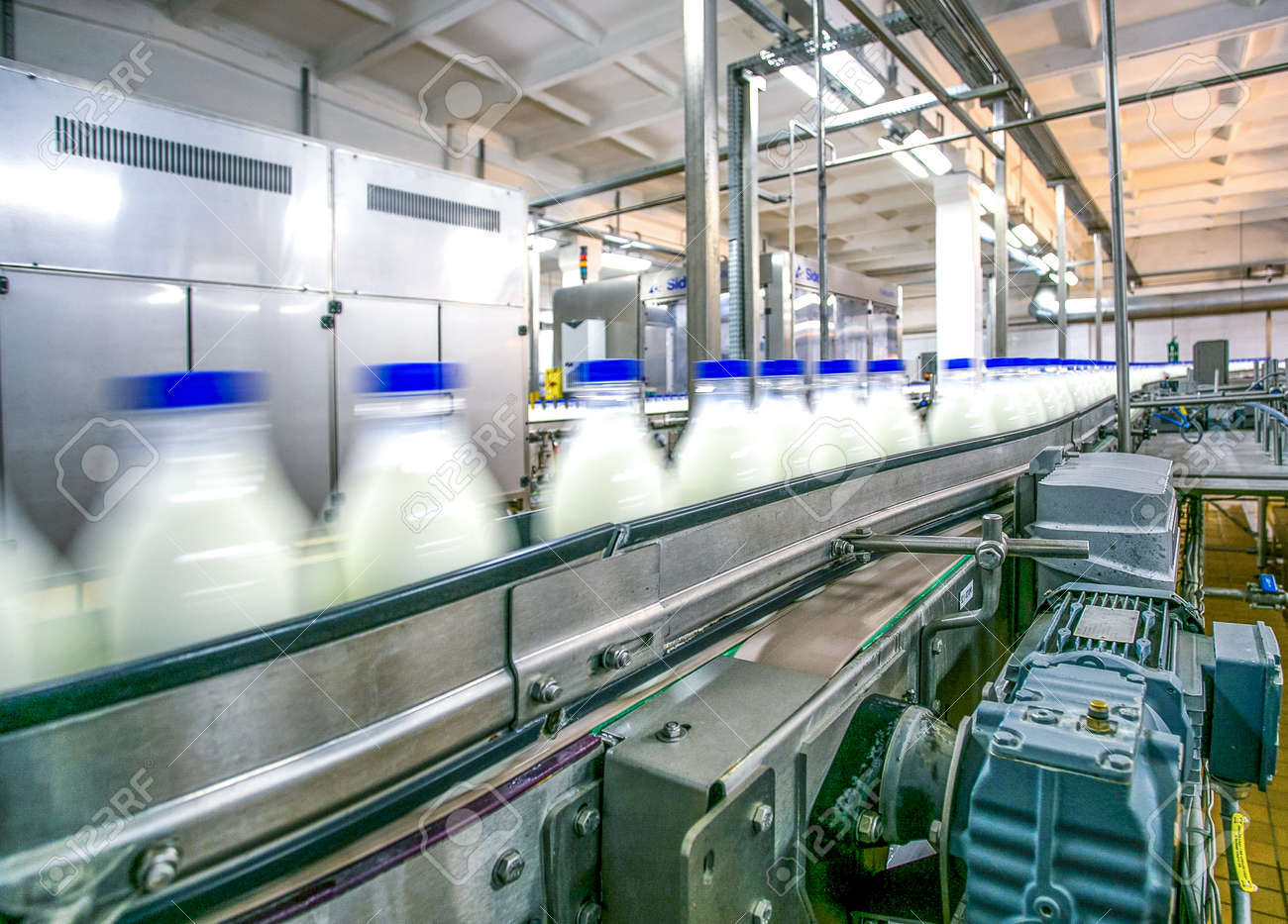 Milk production on line at the factory bottles with milk product in motion focused on conveyer details - 53401428 Milk production on line at the factory bottles with milk product in motion focused on conveyer details - 53401428