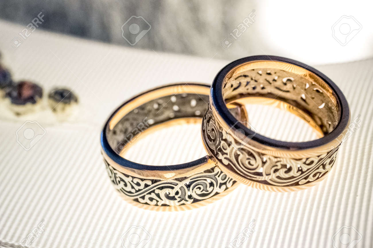 Dos Anillos De Bodas De Oro Con Diseño Raro En La Ancha Cinta Blanca Con Los Cristales Se Cierran Para Arriba Fotos, Retratos, Imágenes Y Fotografía De Archivo Libres Derecho.