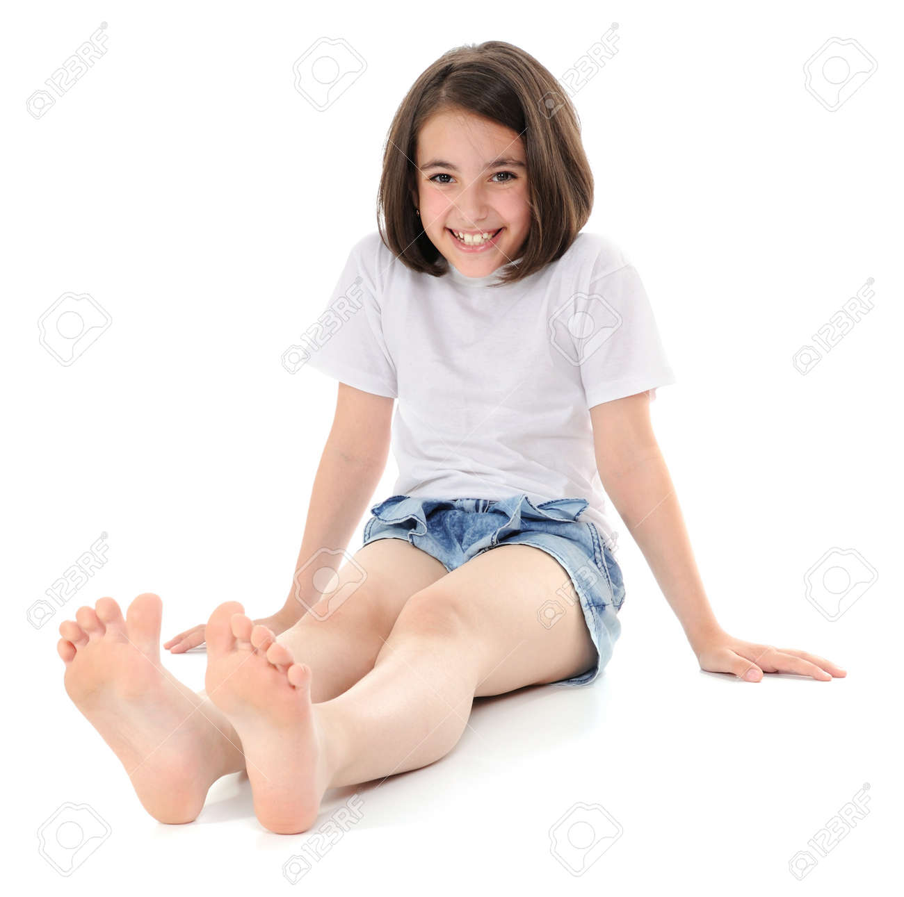 smiling girl sitting on a floor looking at camera stock photo