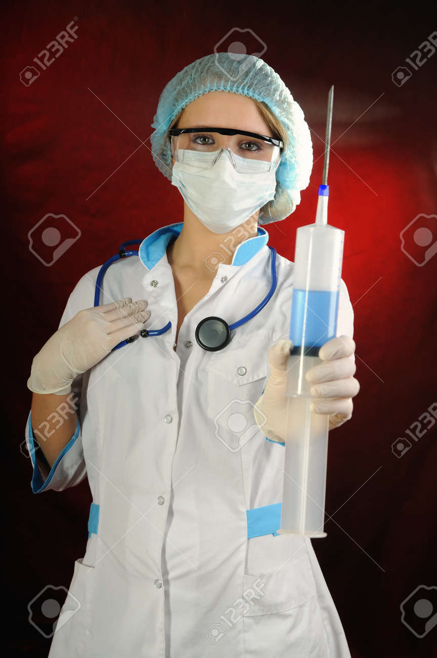 Enfermera De La Celebracion De Una Jeringa Grande El Fondo Rojo