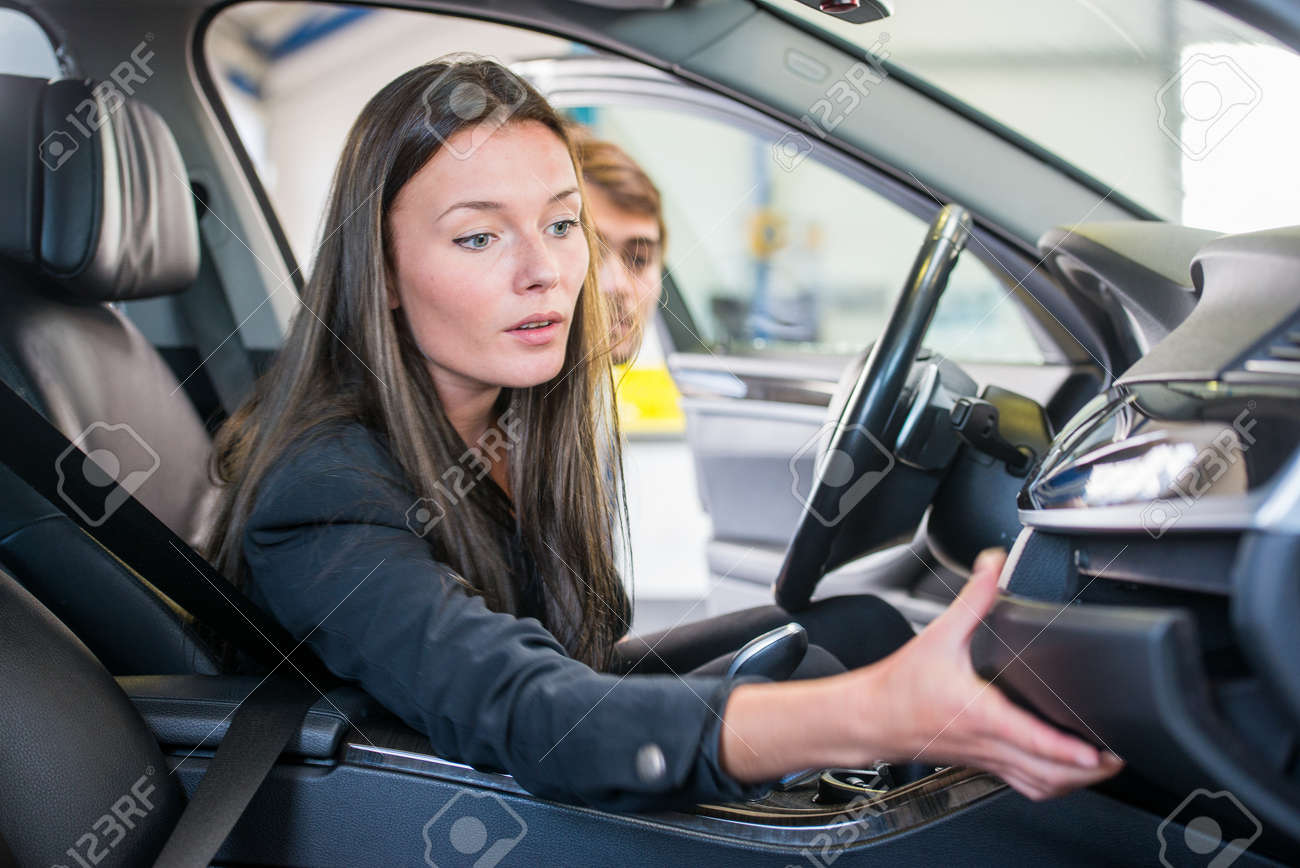 若い女性が ガレージは 小物入れに手を伸ばし 2 番目の手の車を購入しています の写真素材 画像素材 Image