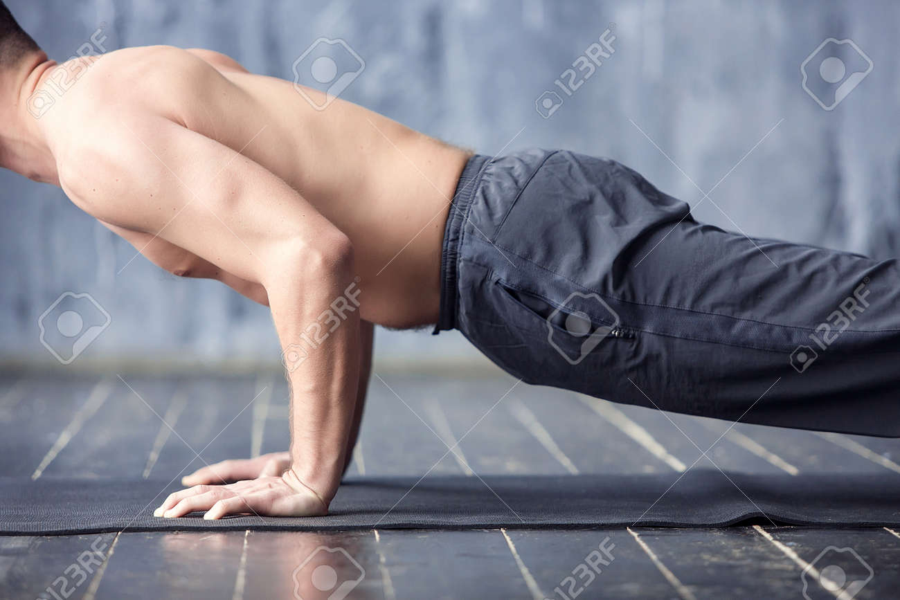 若いヨギ男性プラクティス ヨガのアーサナ チャツランガ Dandasana スタッフの四つの手は 都市スタジオでポーズを取る 黒マットでヨガ男性運動をクローズ アップ の写真素材 画像素材 Image