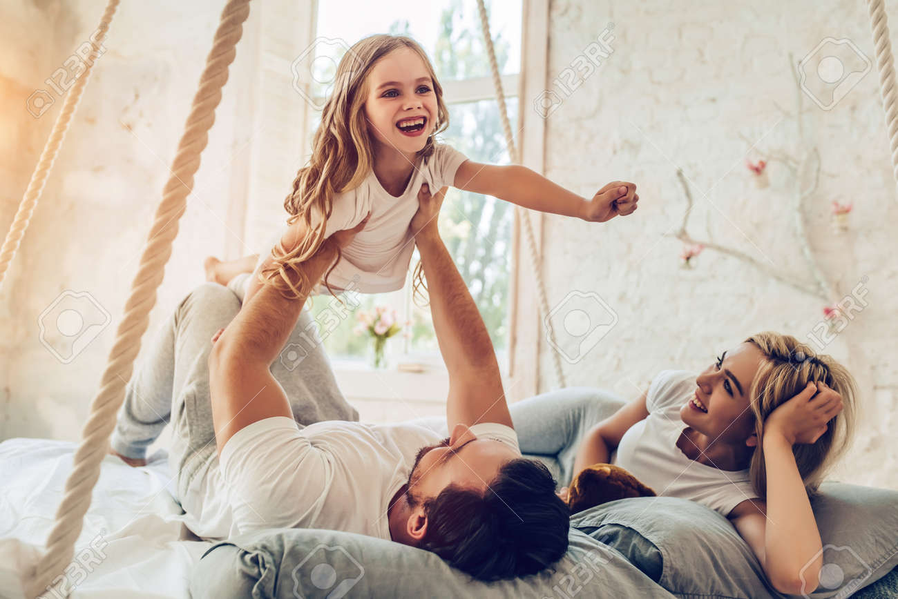 Happy Family Is Having Fun In Bedroom Enjoying Being Together