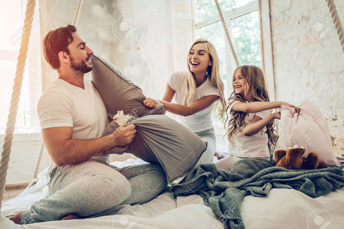 Happy Family Is Having Fun In Bedroom While Pillow Battle Enjoying