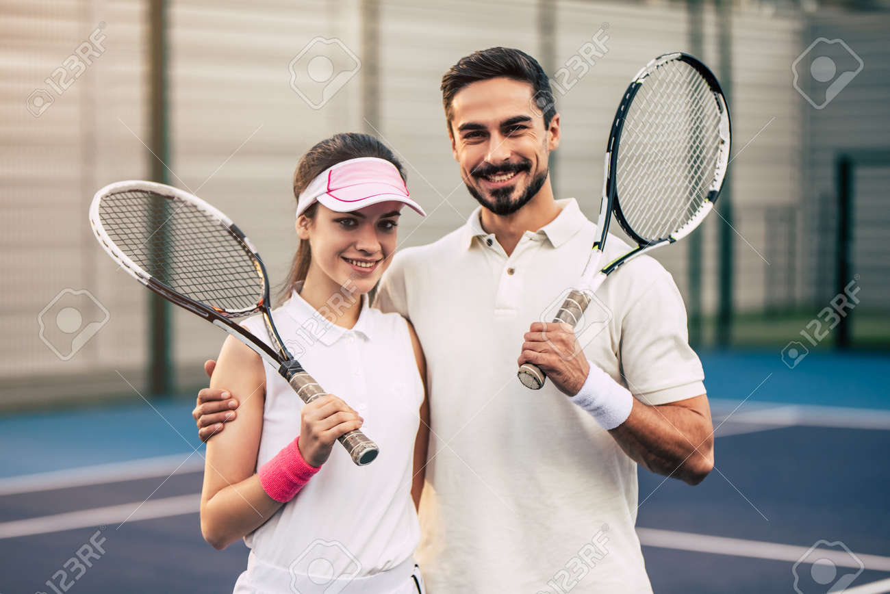 Jovem Casal No Campo De Tenis Homem Bonito E Atraente Mulher Estao Jogando Tenis Abracando Sorrindo E Olhando A Camera Fotos Retratos Imagenes Y Fotografia De Archivo Libres De Derecho Image 91996664