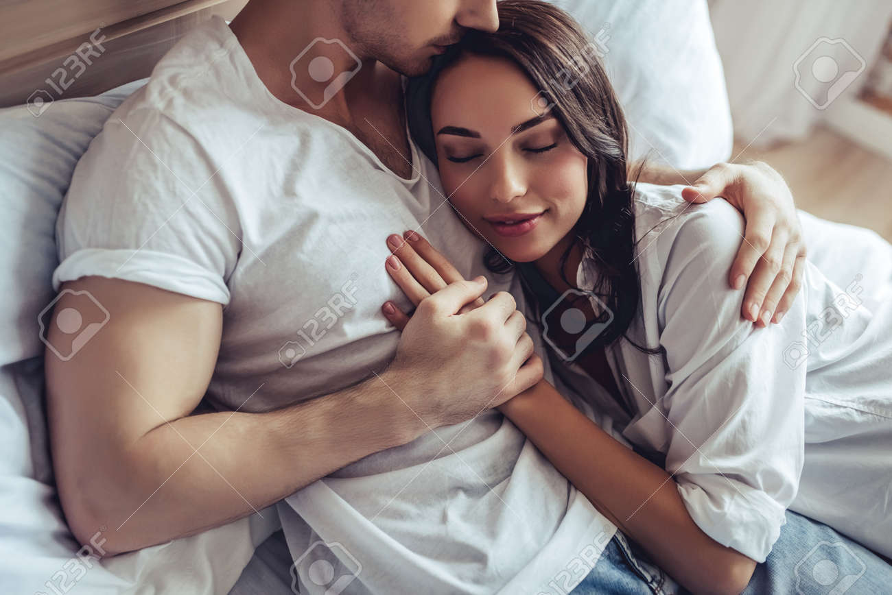 Cropped Image Of Beautiful Young Couple In Bedroom Is Lying On