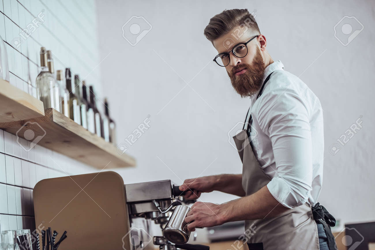 Handsome Male Barista Is Working In Coffee Shop Bearded Man Behind The Bar Counter Handsome Male Barista Is Working In Coffee Shop Bearded Man Behind The Bar Counter