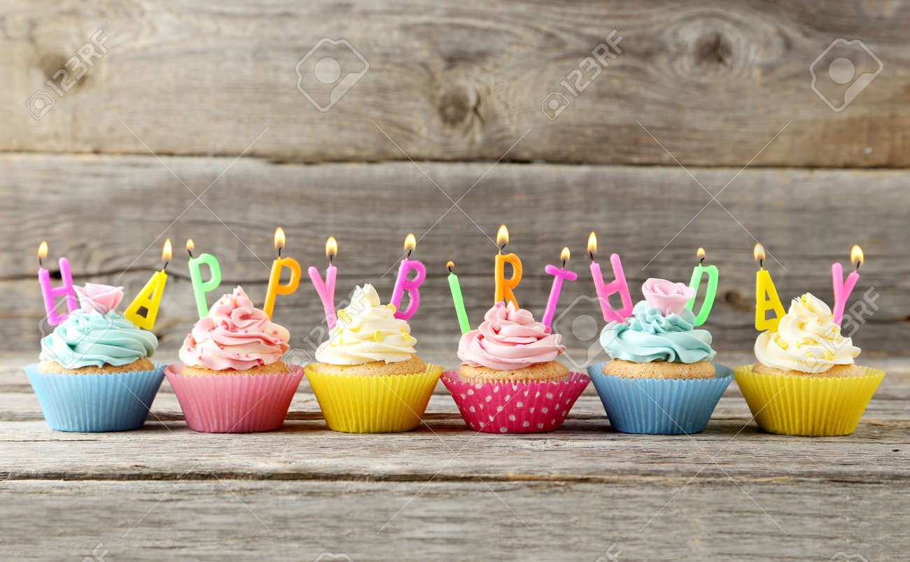 Birthday Cupcakes With Candles On Grey Wooden Background Stock Photo