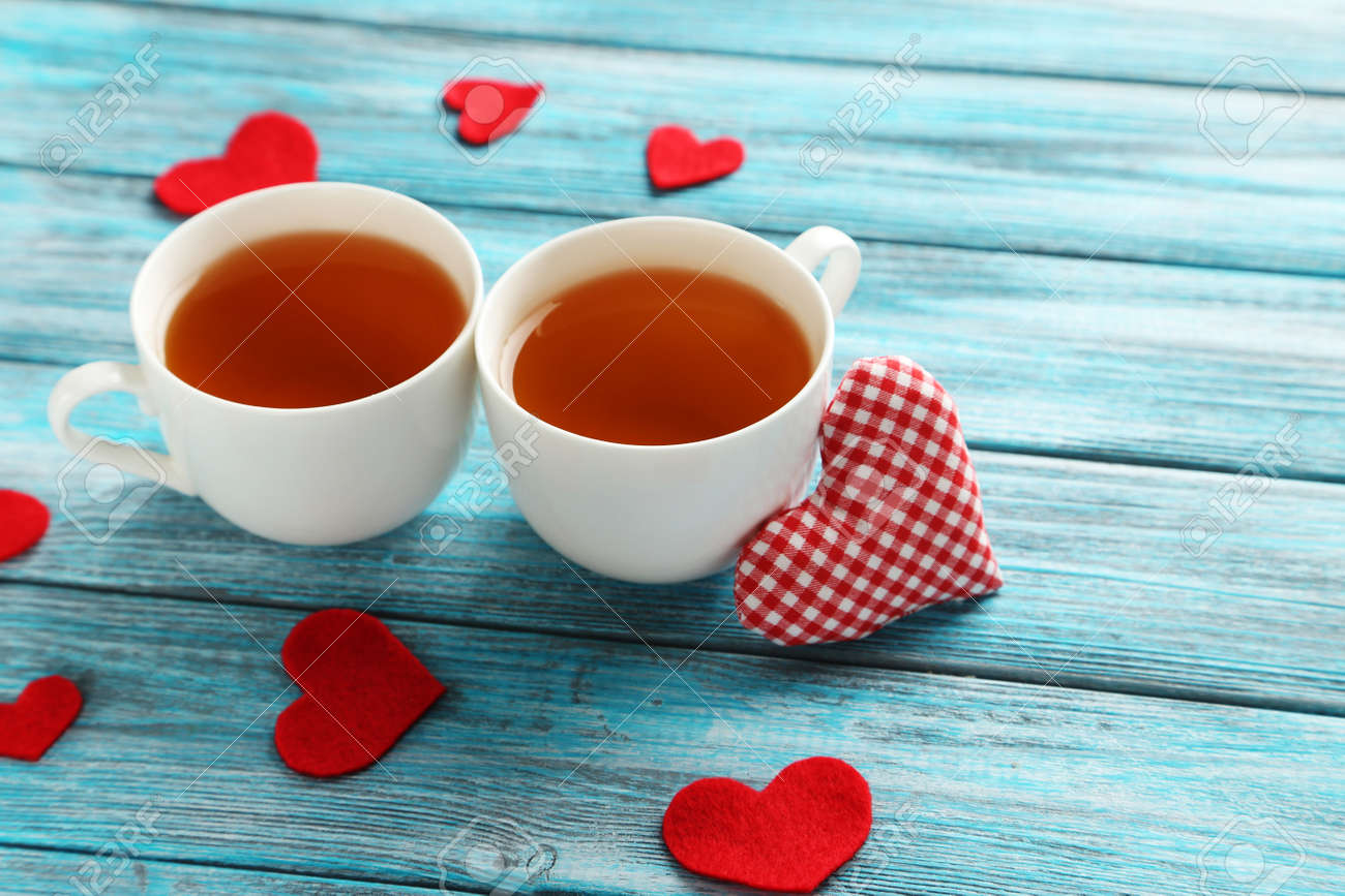 Love hearts with cups of tea on a blue wooden table - 50736125 Love hearts with cups of tea on a blue wooden table - 50736125