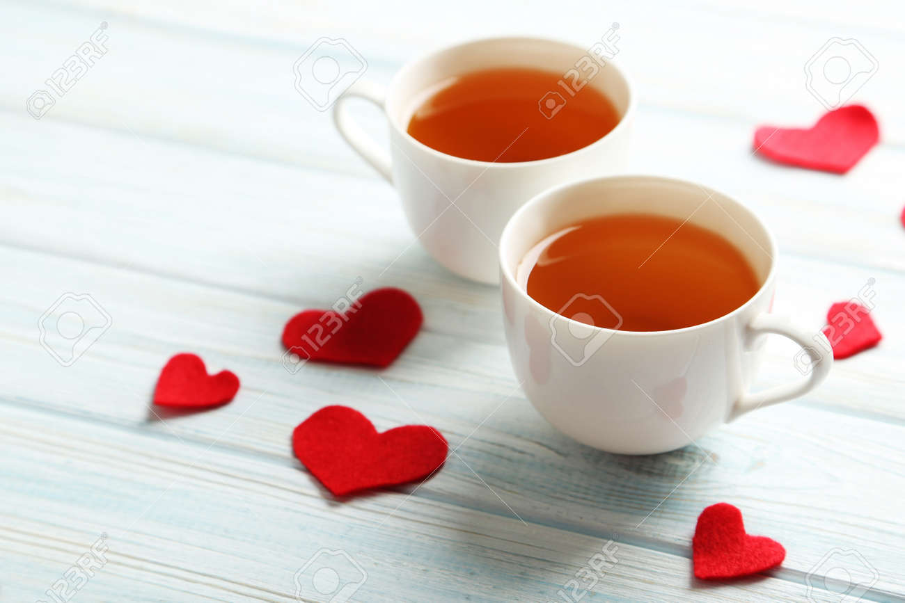 love hearts with cups of tea on a blue wooden table stock photo