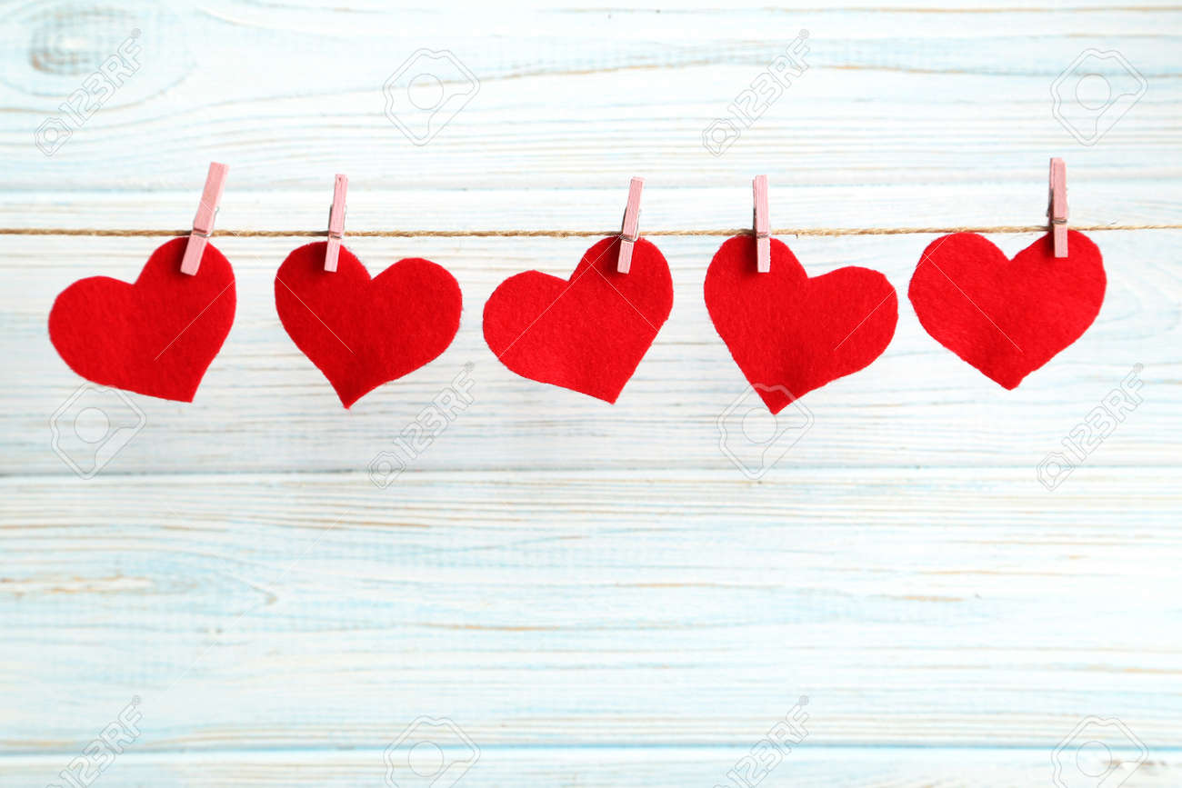 Love hearts hanging on rope on a blue wooden background - 50743821 Love hearts hanging on rope on a blue wooden background - 50743821