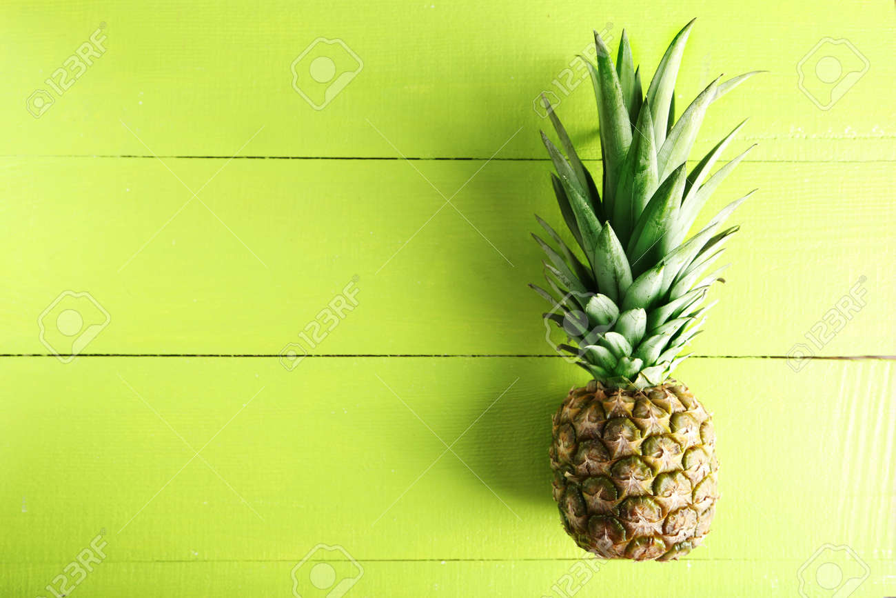 Ripe pineapple on a green wooden background - 51101852 Ripe pineapple on a green wooden background - 51101852
