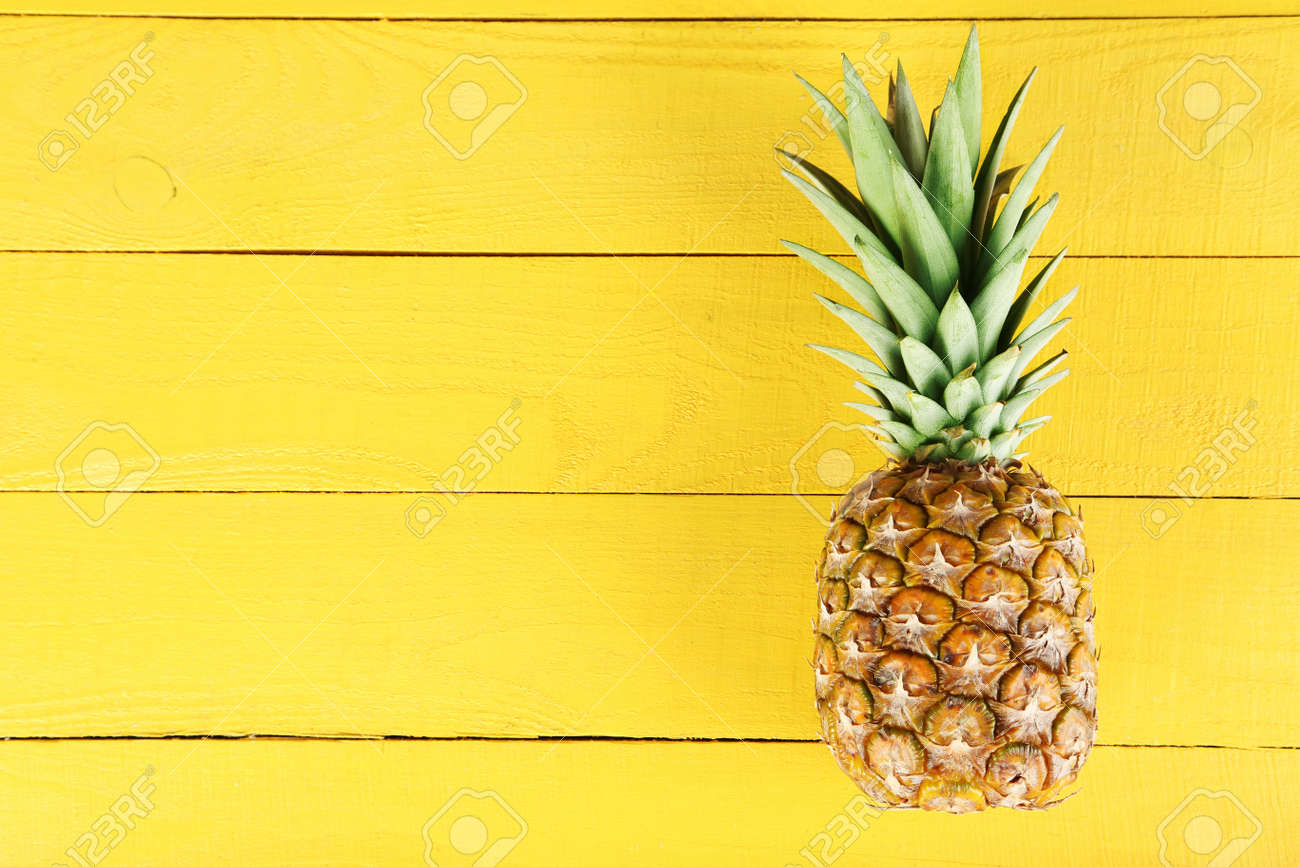 Ripe pineapple on a yellow wooden background - 51102174 Ripe pineapple on a yellow wooden background - 51102174