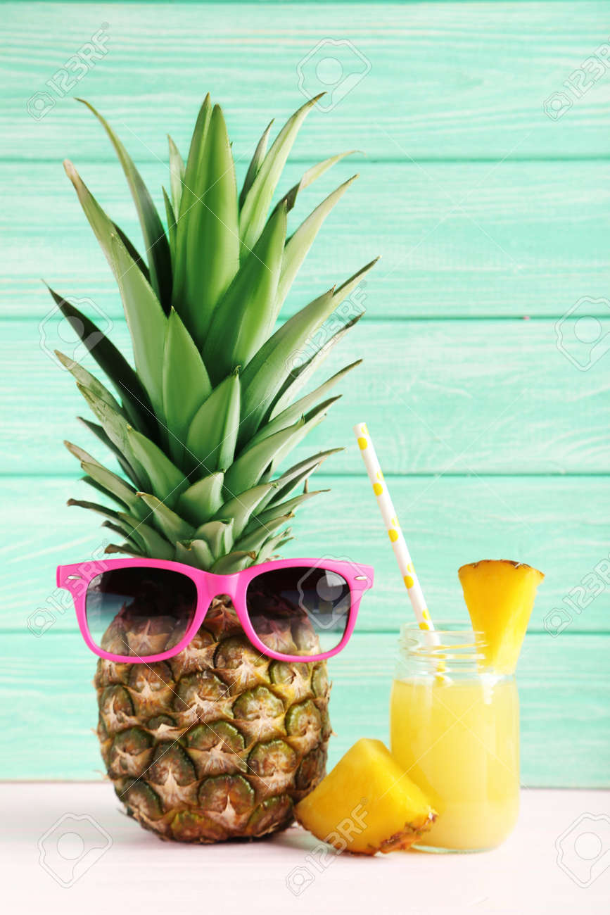 Bottle of pineapple juice on a pink wooden table - 51480231 Bottle of pineapple juice on a pink wooden table - 51480231