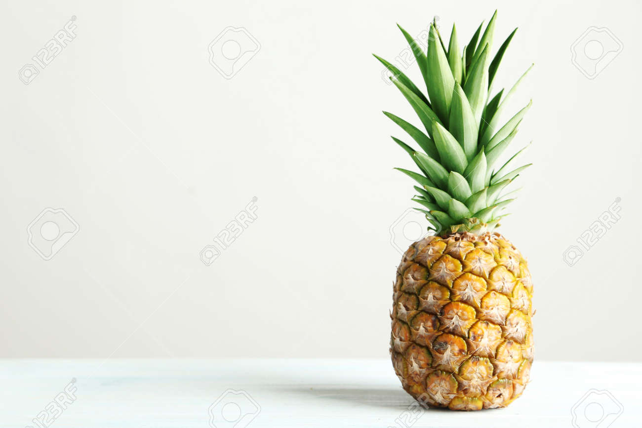 Ripe pineapple on a white wooden table - 52059024 Ripe pineapple on a white wooden table - 52059024