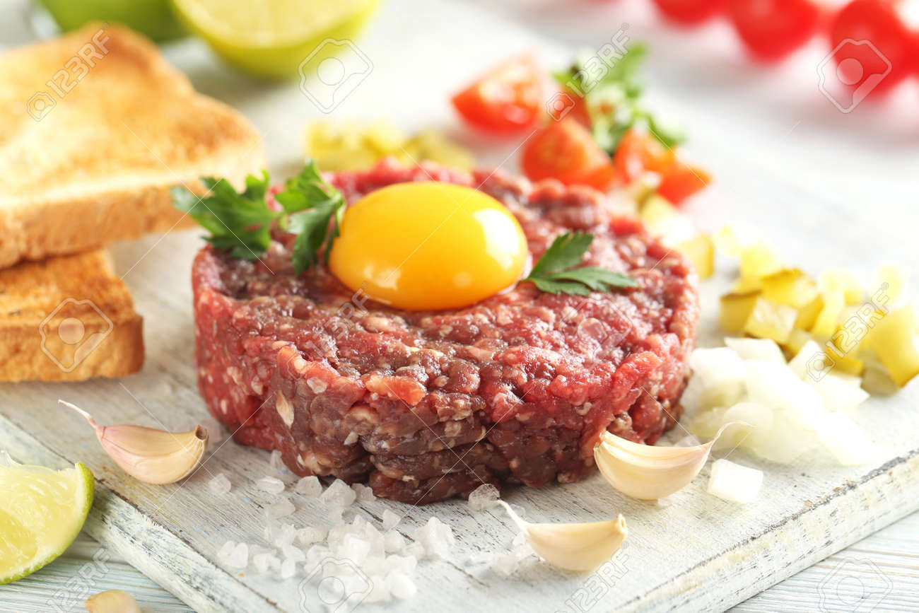 Beef tartare with egg yolk on a blue wooden table - 56732955 Beef tartare with egg yolk on a blue wooden table - 56732955