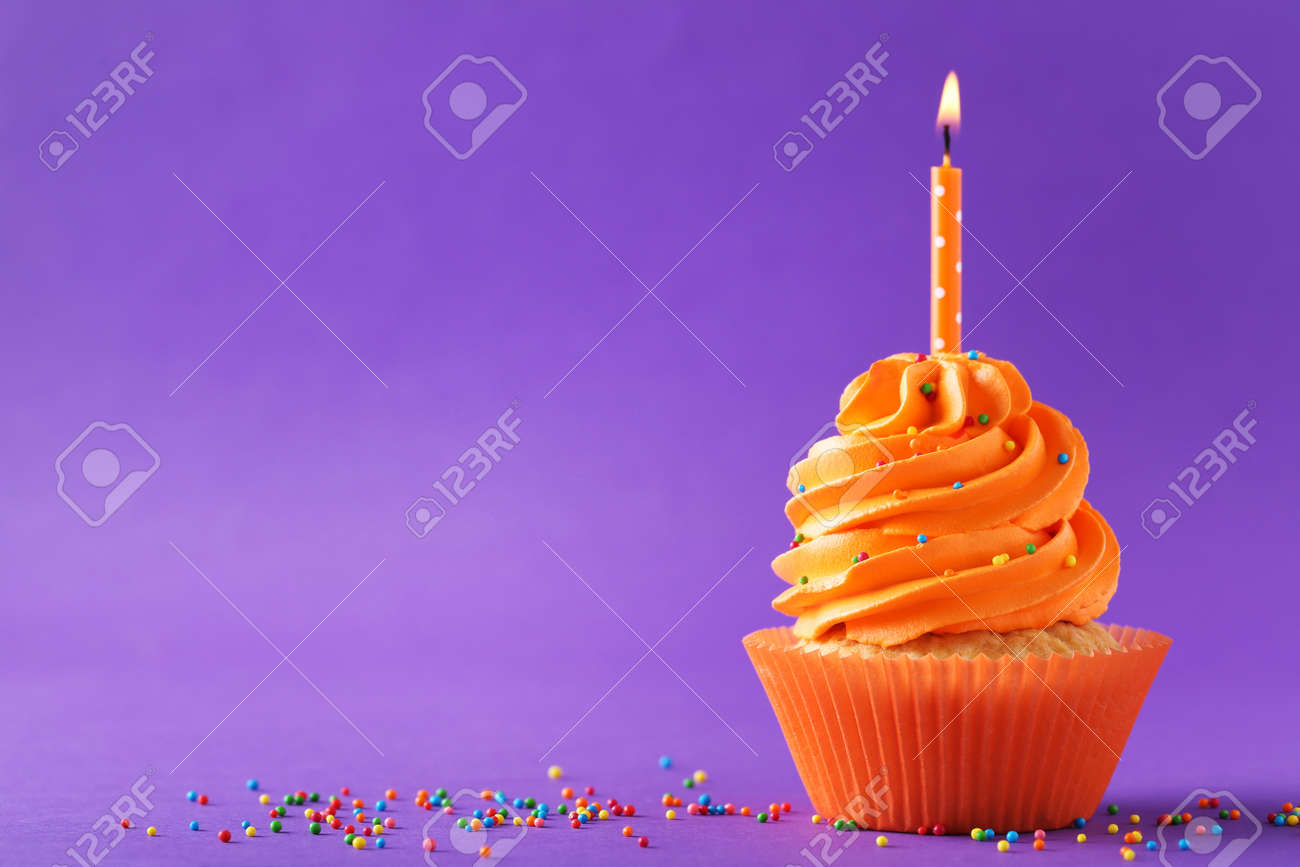 Tasty cupcakes with candle on a purple background - 87206672 Tasty cupcakes with candle on a purple background - 87206672