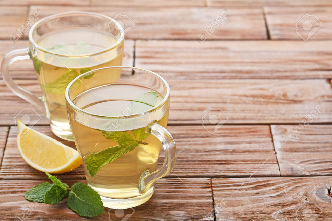 Cup of tea with mint leafs and lemon on wooden table - 90080194 Cup of tea with mint leafs and lemon on wooden table - 90080194