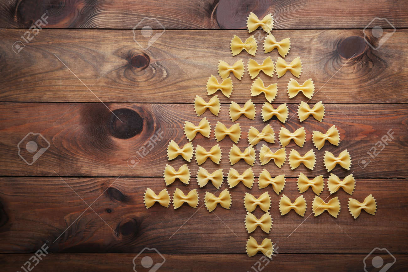 Christmas tree made from bow tie pasta on wooden table - 91253905 Christmas tree made from bow tie pasta on wooden table - 91253905