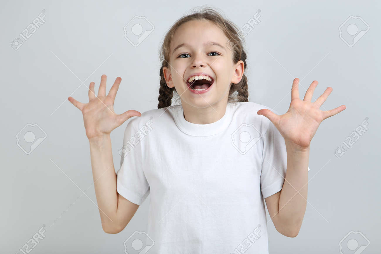 Surprised young girl on grey background - 104525777 Surprised young girl on grey background - 104525777