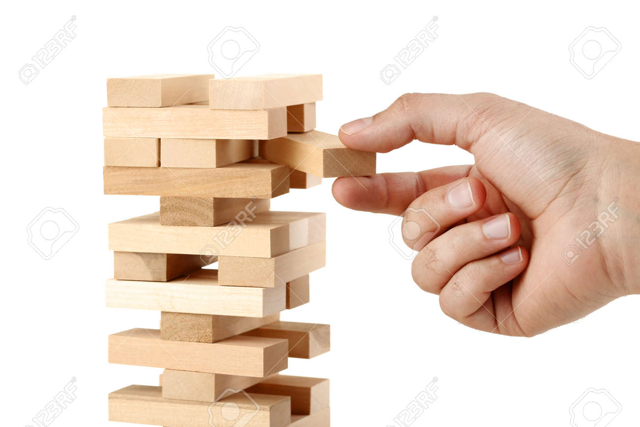Male hand playing wooden blocks tower game on white background - 107070673 Male hand playing wooden blocks tower game on white background - 107070673