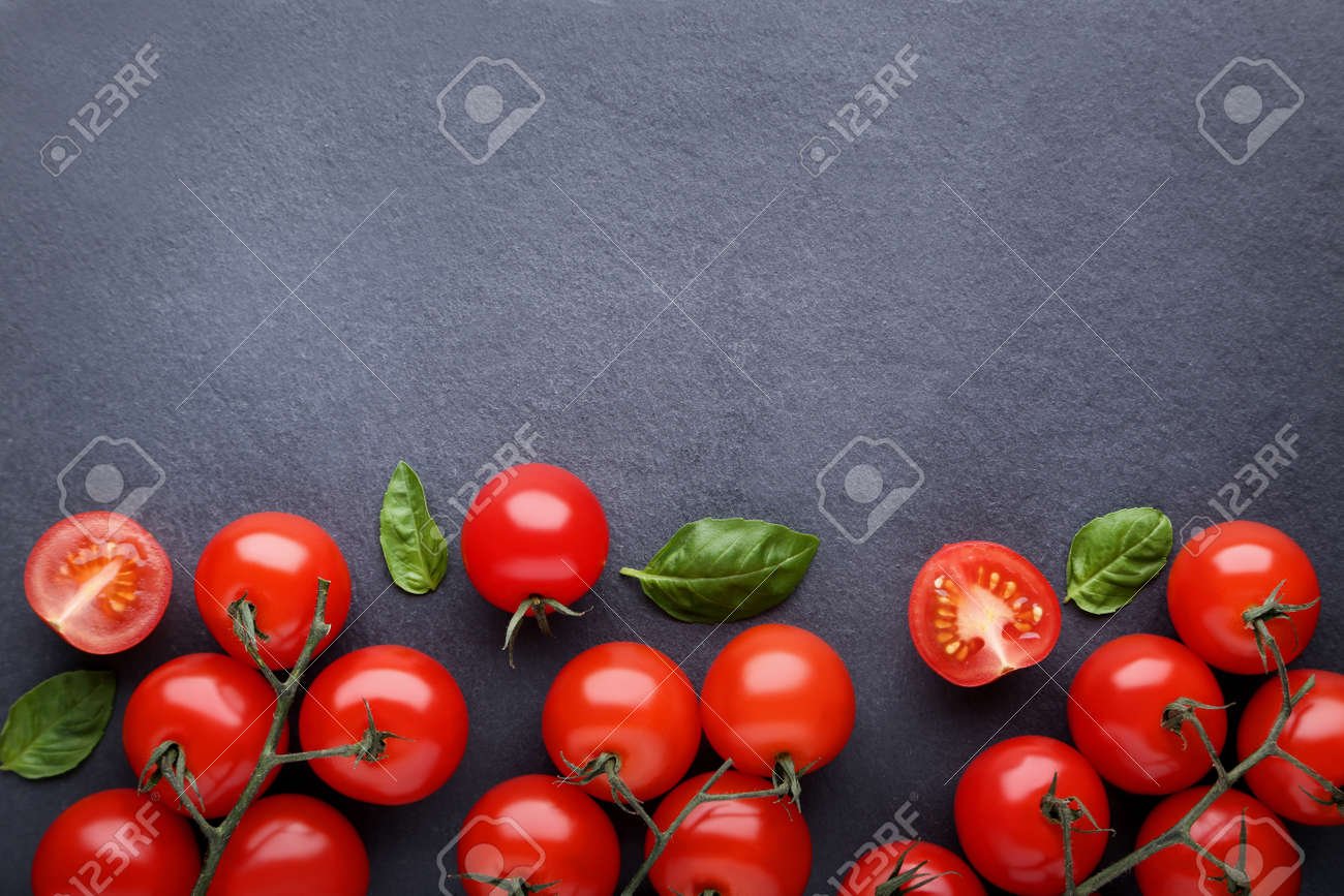 Cherry tomatoes with basil leafs on black background - 115989173 Cherry tomatoes with basil leafs on black background - 115989173