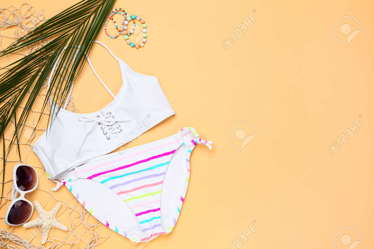 Fashion swimsuit with palm leaf, sunglasses and starfish on beige background - 123704797 Fashion swimsuit with palm leaf, sunglasses and starfish on beige background - 123704797