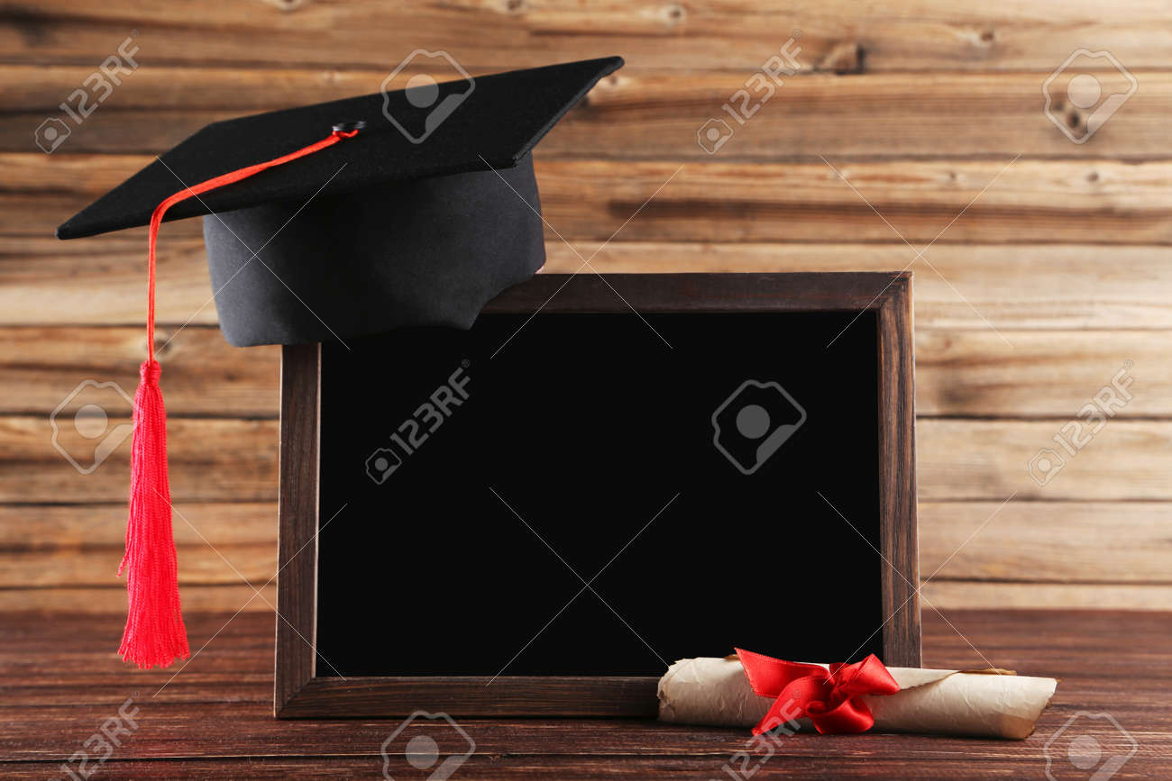 Graduation cap with diploma and blank frame on brown wooden table - 126161527 Graduation cap with diploma and blank frame on brown wooden table - 126161527