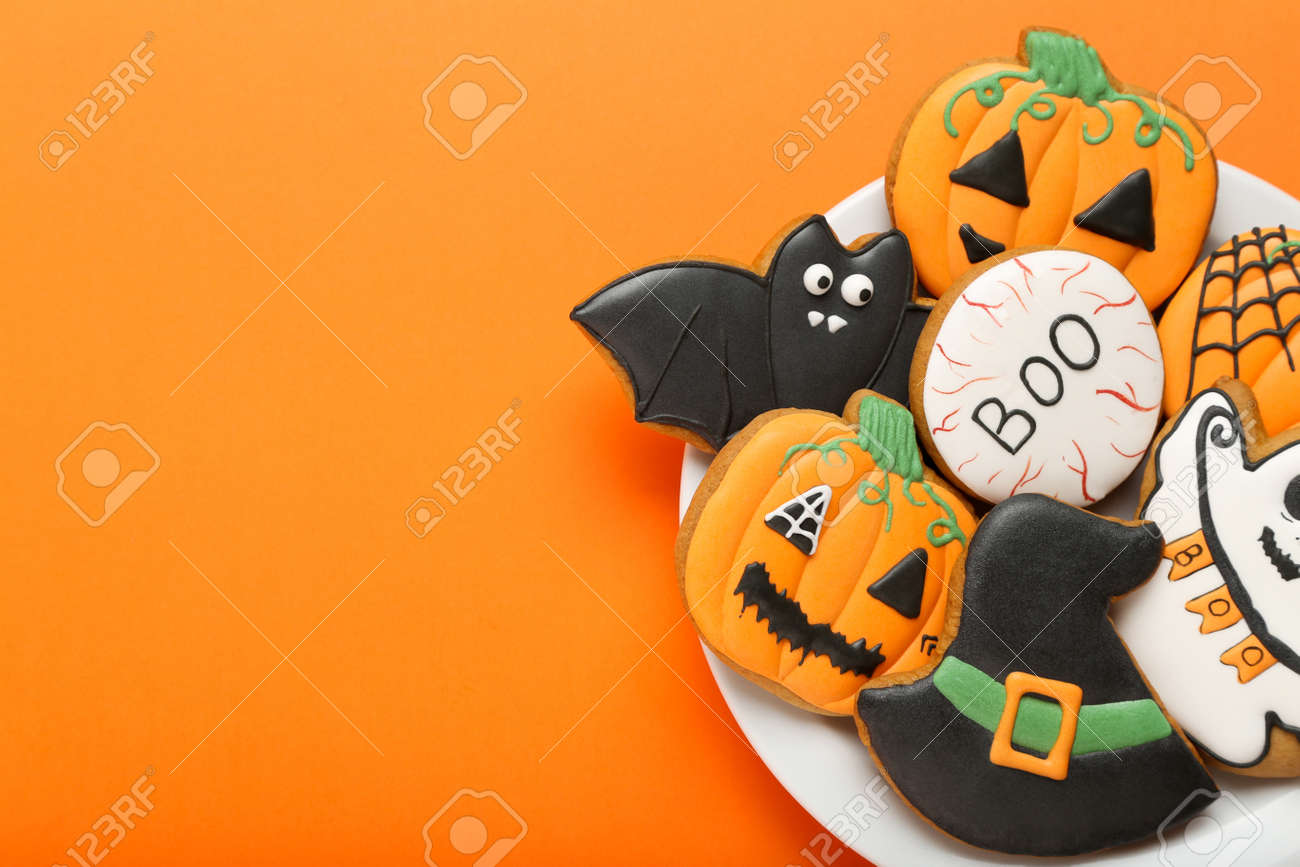 Halloween gingerbread cookies in plate on orange background - 129766045 Halloween gingerbread cookies in plate on orange background - 129766045