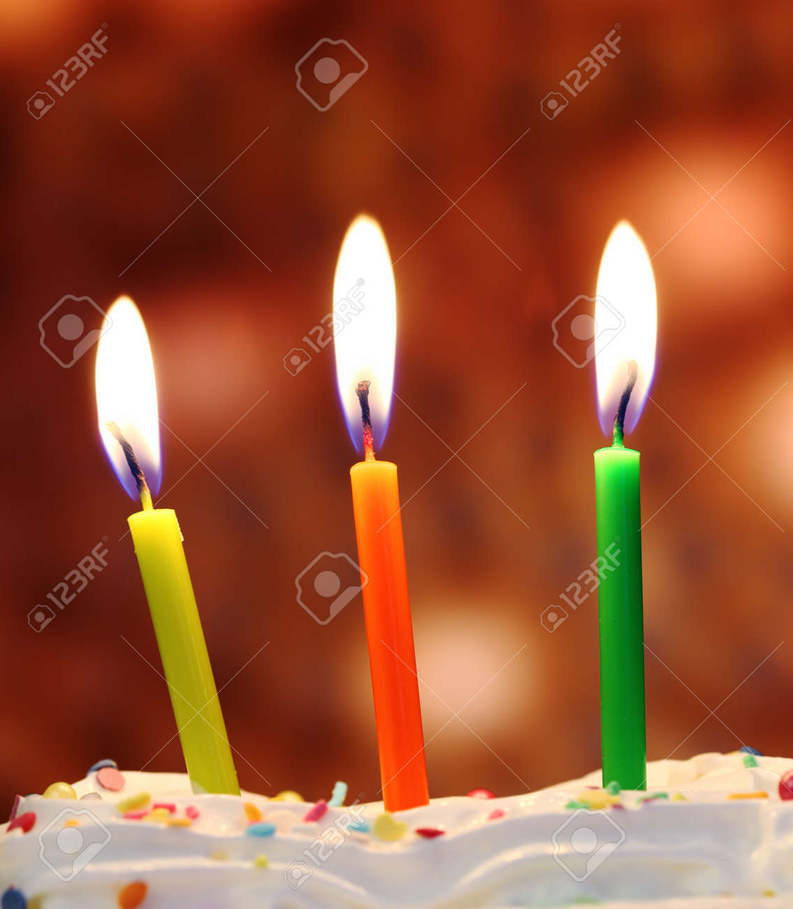 three lit birthday candles close up shallow dof stock photo