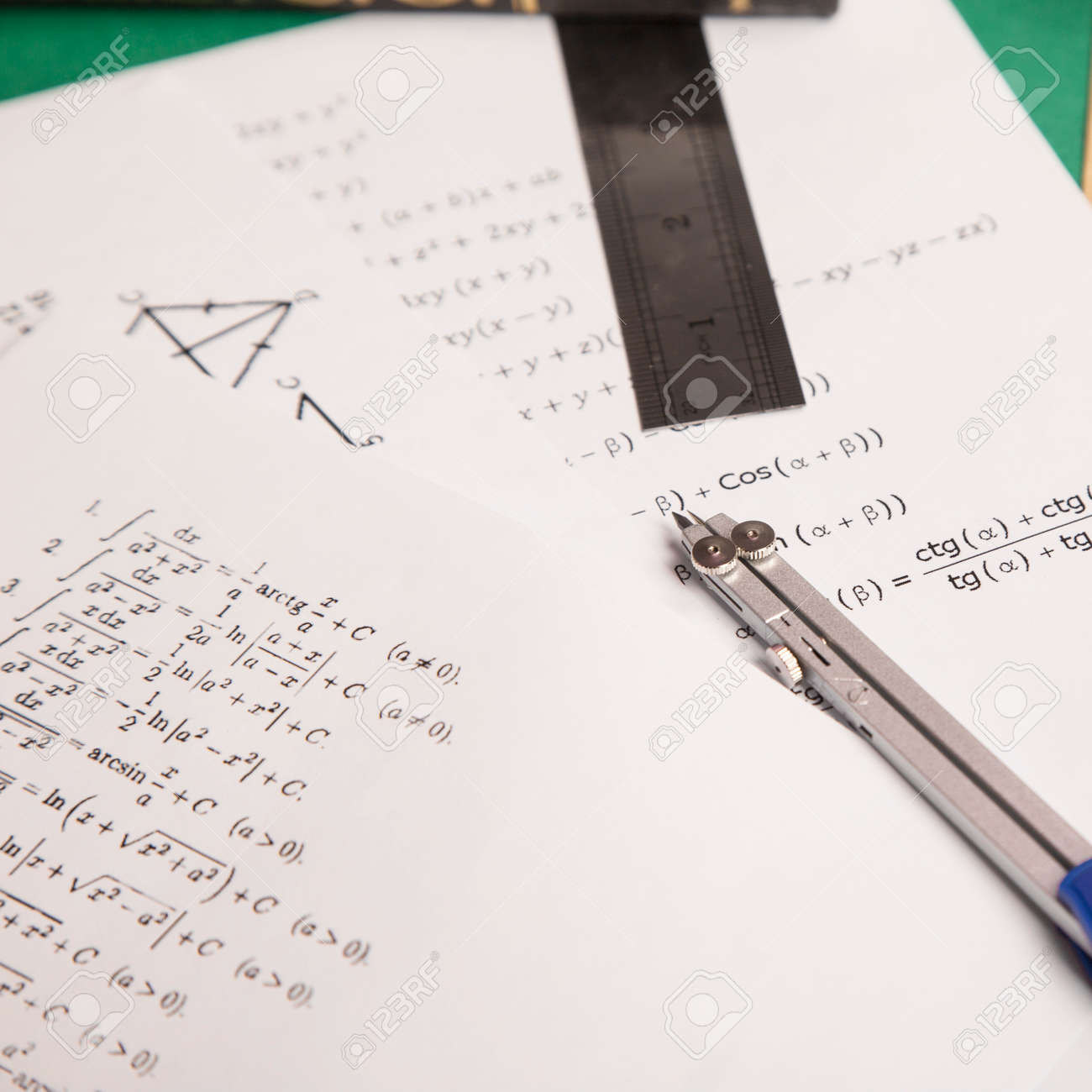 数式、定規、グリーンペーパーの背景上のコンパスのペアを持つ論文の