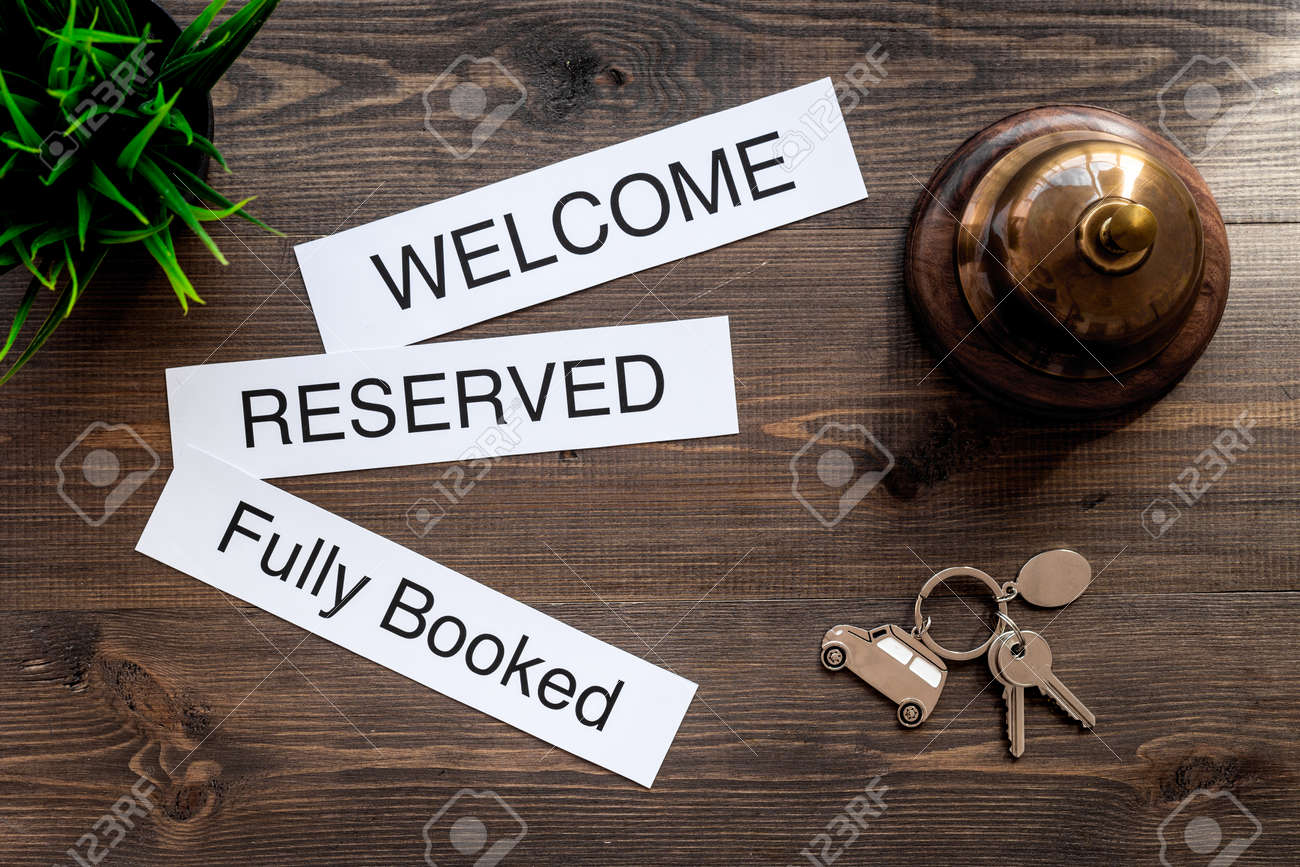 ホテルです 言葉を歓迎 完全予約 暗い木製のテーブル トップ ビューで予約 の写真素材 画像素材 Image