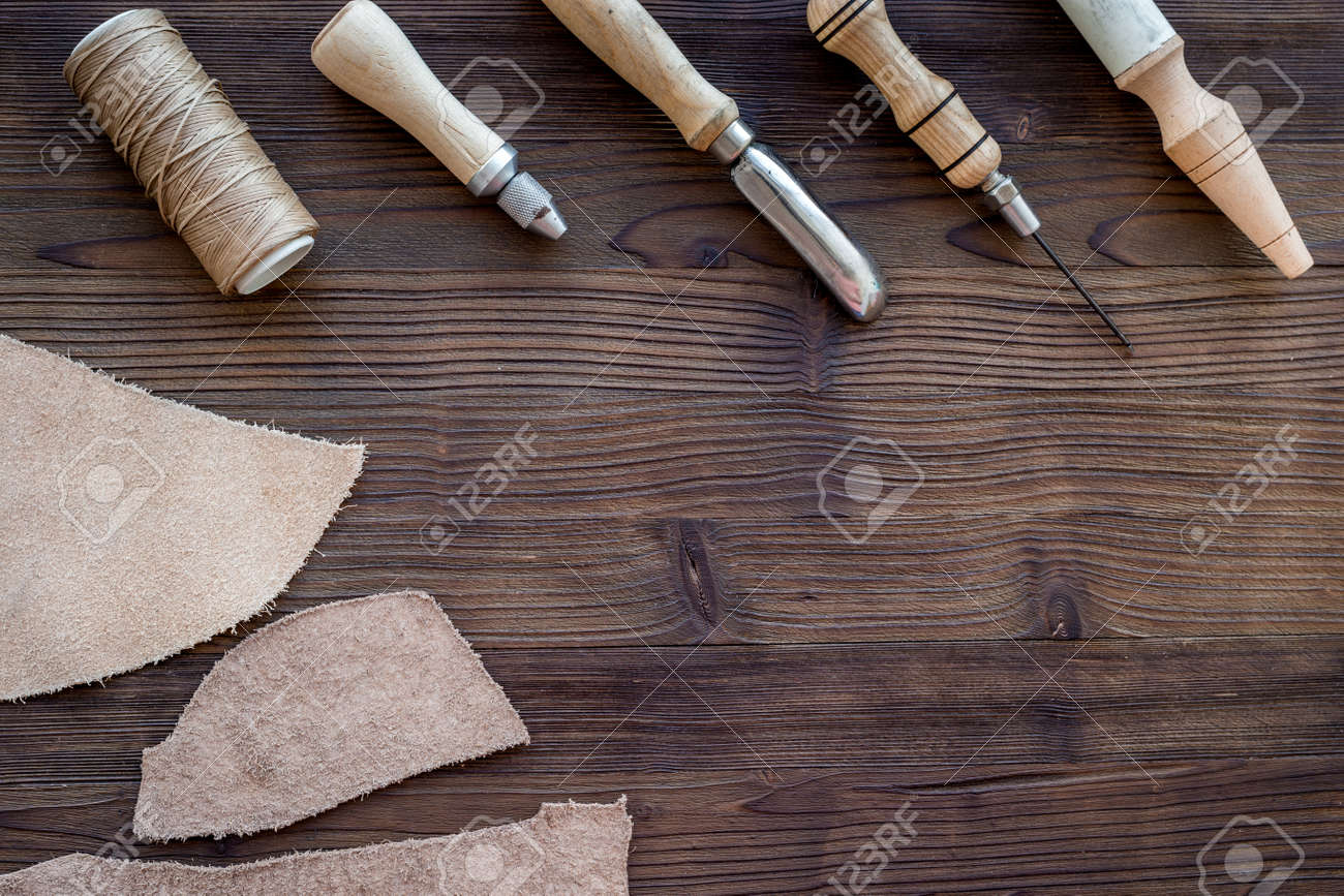 Leather craft. Knife, awl and other tools on dark wooden background top view copyspace - 84046199 Leather craft. Knife, awl and other tools on dark wooden background top view copyspace - 84046199