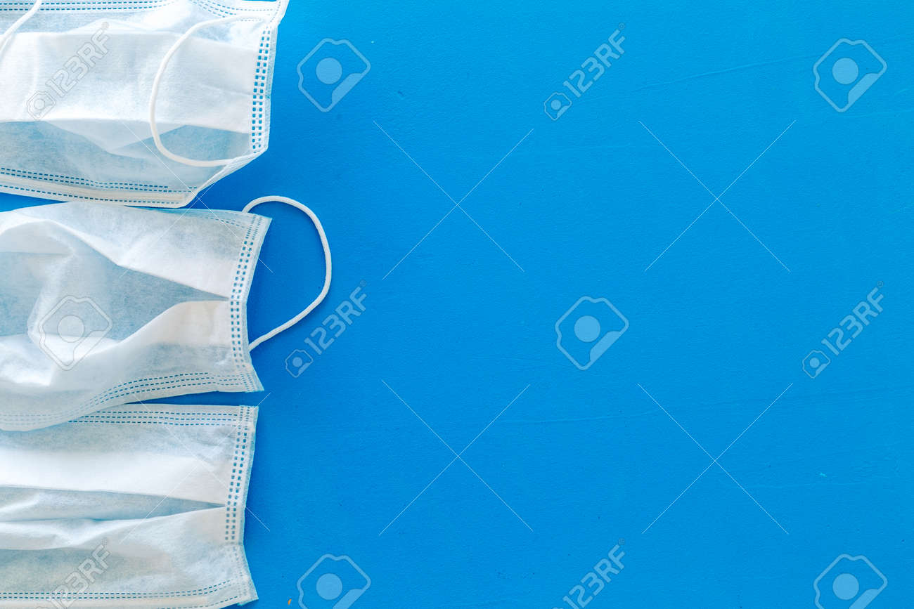 Flu prevention concept. Medical face mask on blue background top view space for text frame - 130332593 Flu prevention concept. Medical face mask on blue background top view space for text frame - 130332593