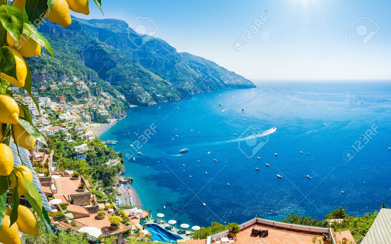 Beautiful Positano with comfortable beaches and clear blue sea on Amalfi Coast in Campania, Italy. Amalfi coast is popular travel and holyday destination in Europe. Ripe yellow lemons in foreground. - 129675699 Beautiful Positano with comfortable beaches and clear blue sea on Amalfi Coast in Campania, Italy. Amalfi coast is popular travel and holyday destination in Europe. Ripe yellow lemons in foreground. - 129675699