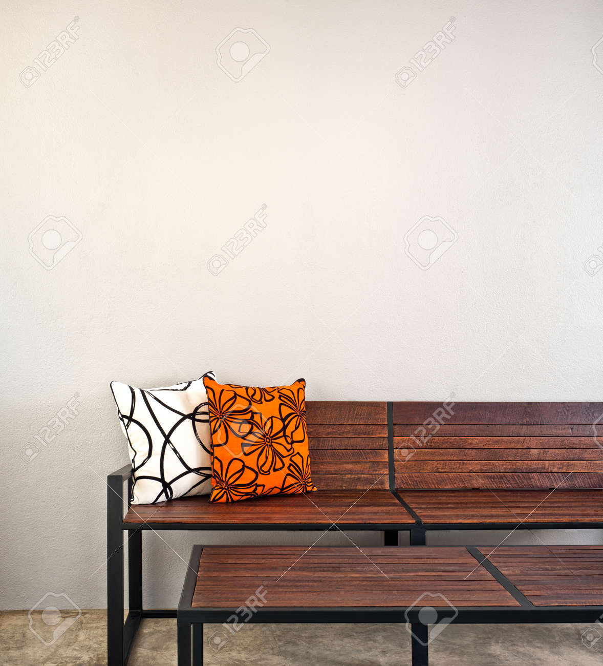 Banco de jardín como muebles de interior con dos almohadas Banco de jardín como muebles de interior con dos almohadas