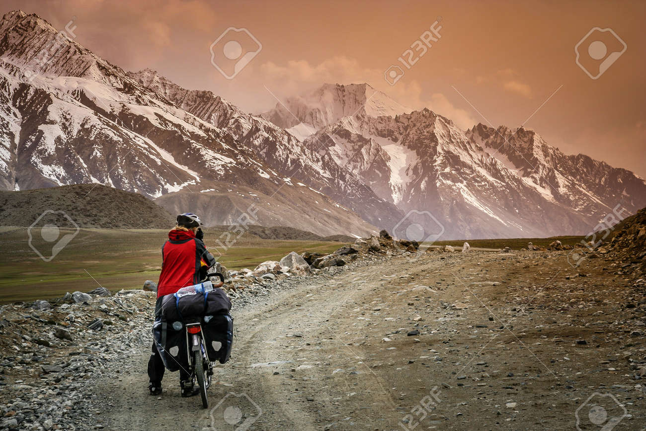 パキスタン北部シャンドゥール峠に向かって困難な山岳道路上の自転車の女性 の写真素材 画像素材 Image