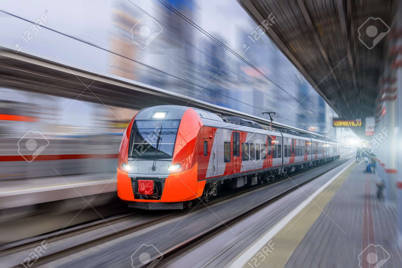 High speed train rides at high speed at the railway station in the city - 101047872 High speed train rides at high speed at the railway station in the city - 101047872