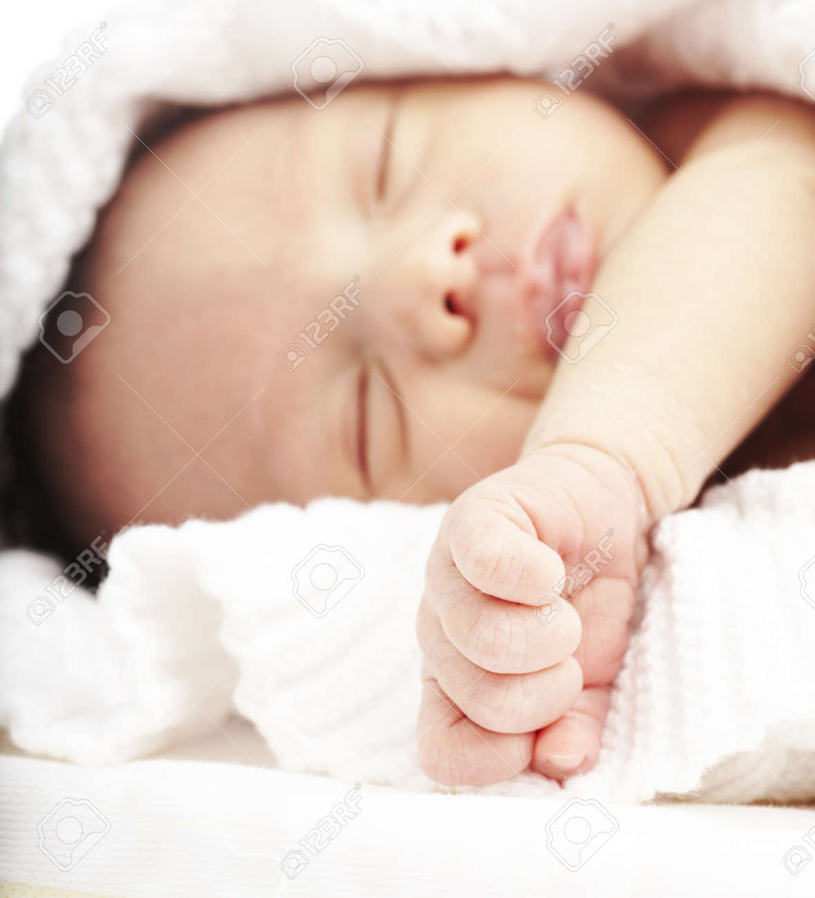 タオルの下にベッドで寝ている生まれたばかりの赤ちゃんの肖像画 の写真素材 画像素材 Image