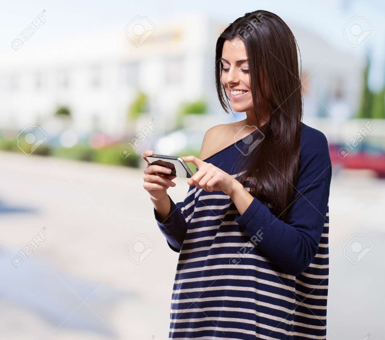 portrait of young woman touching a modern mobile at street - 16252258 portrait of young woman touching a modern mobile at street - 16252258