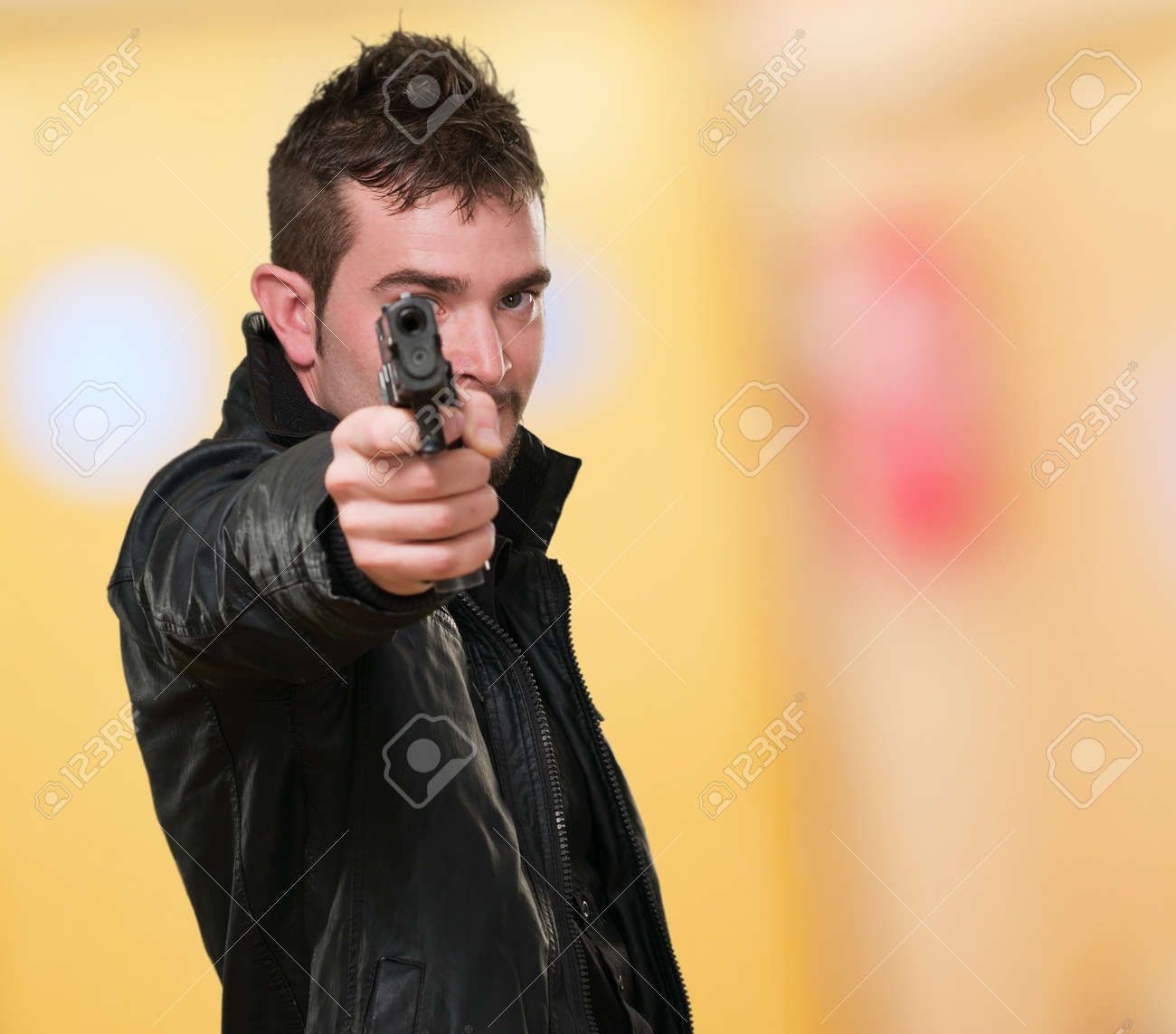 抽象画の背景に対して銃を指している革のジャケットを持つ男 の写真素材 画像素材 Image 抽象画の背景に対して銃を指している革のジャケットを持つ男 の写真素材 画像素材 Image