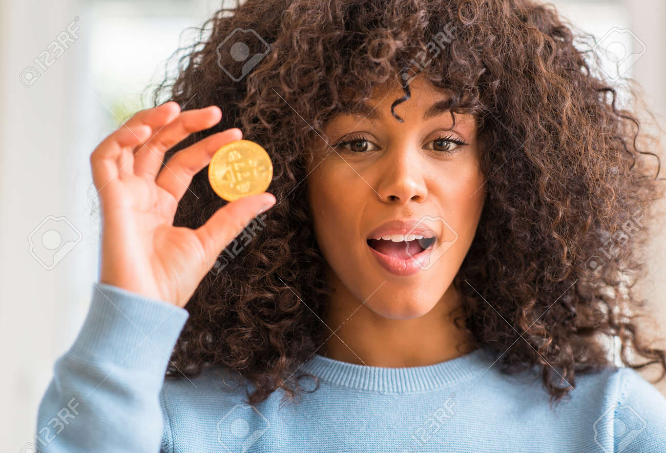 African American Woman Holding Golden Bitcoin Cryptocurrency At Home Scared In Shock With A Surprise Face Afraid And Excited With Fear Expression Stock Photo Picture And Royalty Free Image Image 103901431