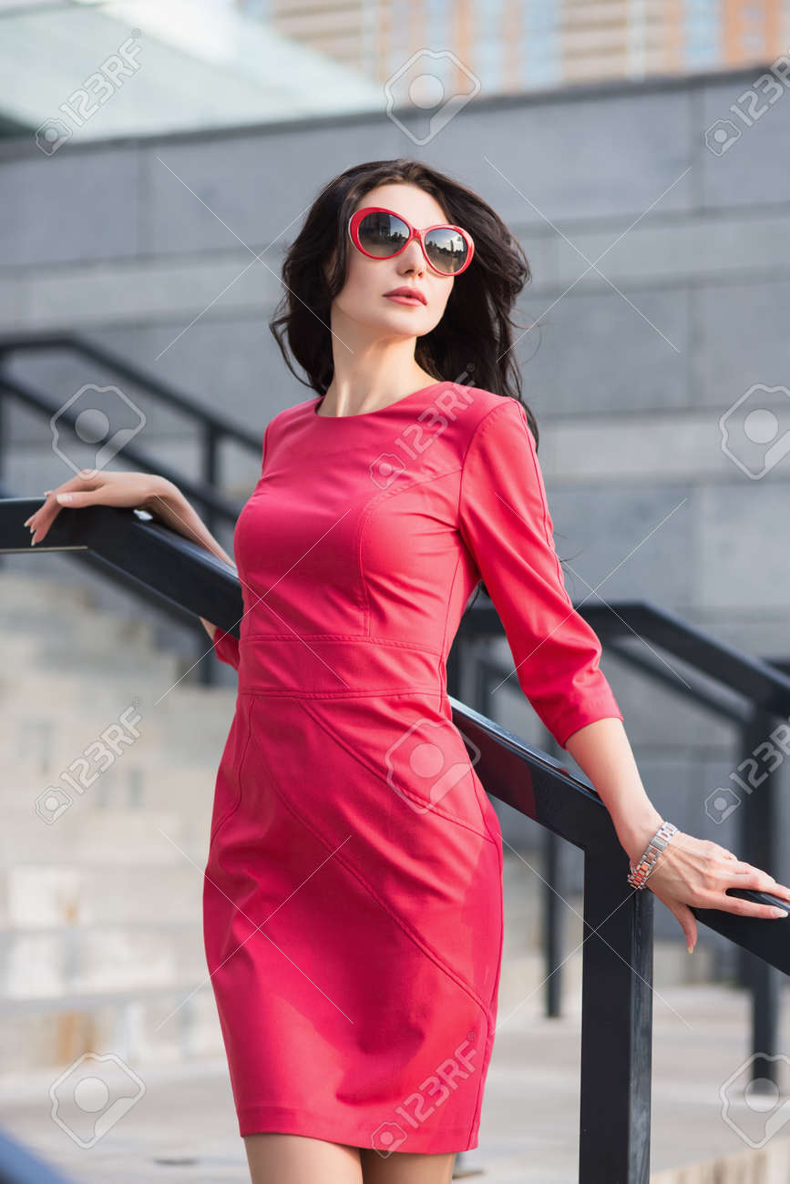 Sexy Slim Lady In Red Dress And Sunglasses Posing Near The Stairs Outdoors Stock Photo Sexy Slim Lady In Red Dress And Sunglasses Posing Near The Stairs Outdoors Stock Photo