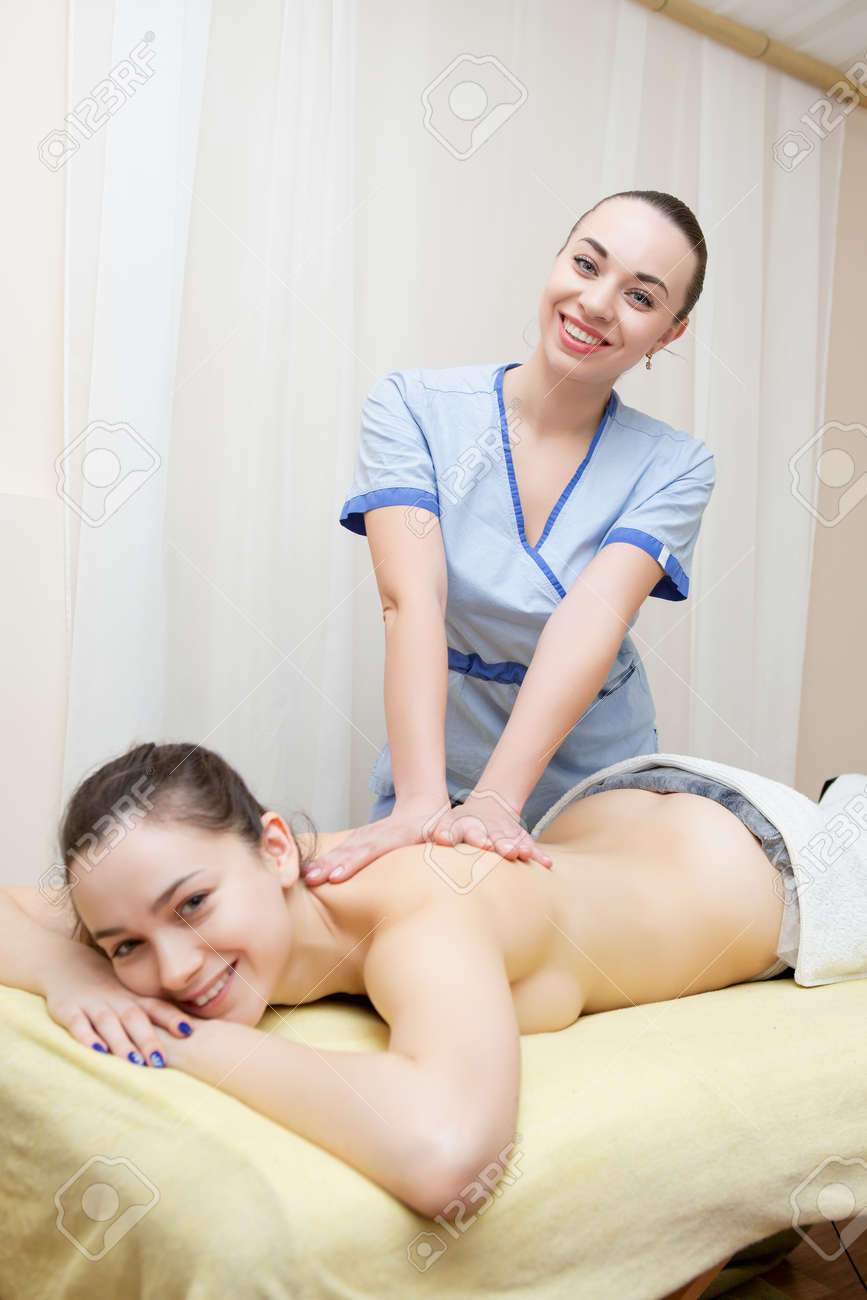 Young Masseuse Massages A Woman Lying Naked On A Massage Table Stock Photo,  Picture and Royalty Free Image. Image 139257798.