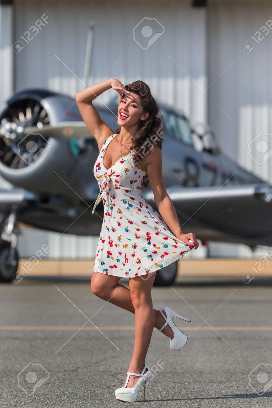 A brunette model in vintage clothing with a pilot and a WW II aircraft - 44956443 A brunette model in vintage clothing with a pilot and a WW II aircraft - 44956443