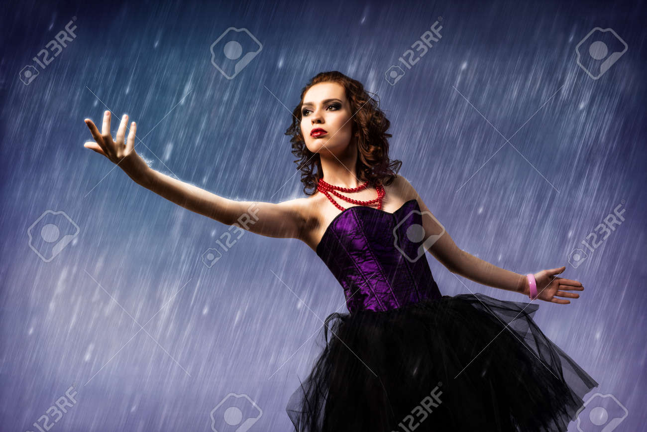 Young Woman Dancing In The Rain Held Up His Hand And Looks At