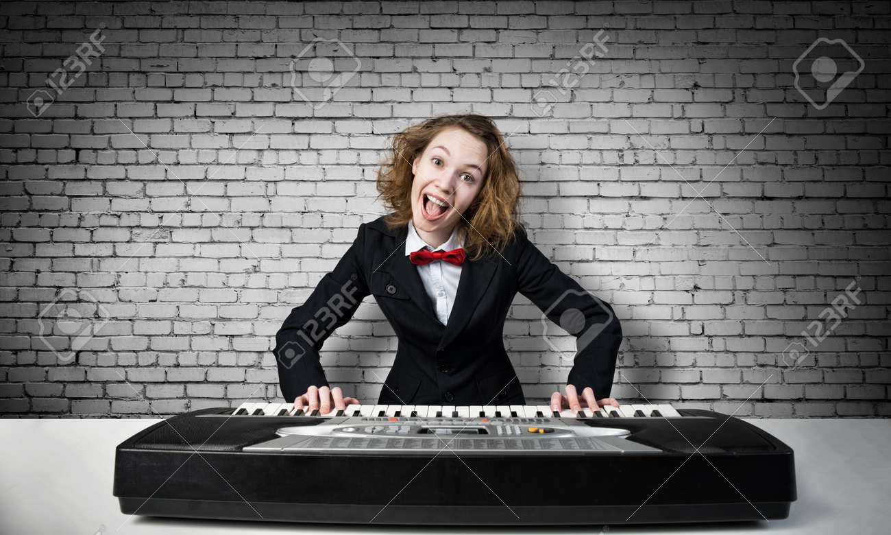 面白い女のスーツと蝶ネクタイのピアノを弾く の写真素材 画像素材 Image