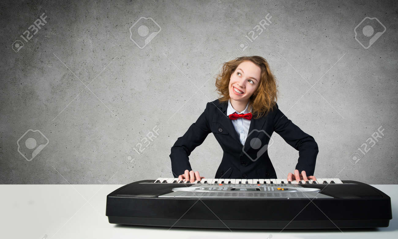 面白い女のスーツと蝶ネクタイのピアノを弾く の写真素材 画像素材 Image