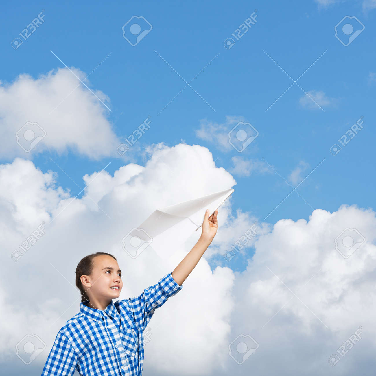 青い空を背景に紙飛行機を屋外開催のかわいい女の子 の写真素材 画像素材 Image